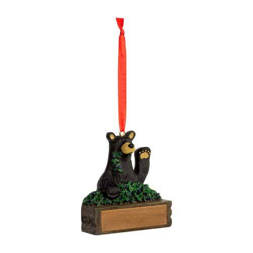 A hanging ornament with a black bear with a huckleberry bush on a rectangular base that can be personalized, displayed angled to the right.
