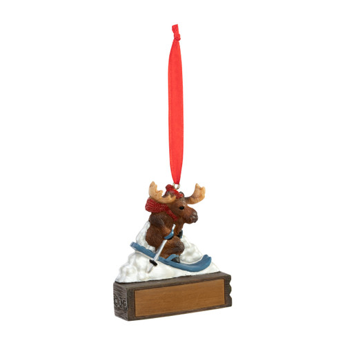 An ornament of a moose skiing down a slope of snow, hanging from a red ribbon. There is a spot in front for customization, displayed angled to the right.