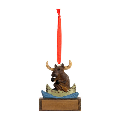 A hanging ornament with a moose paddling a canoe on a rectangular base that can be personalized.