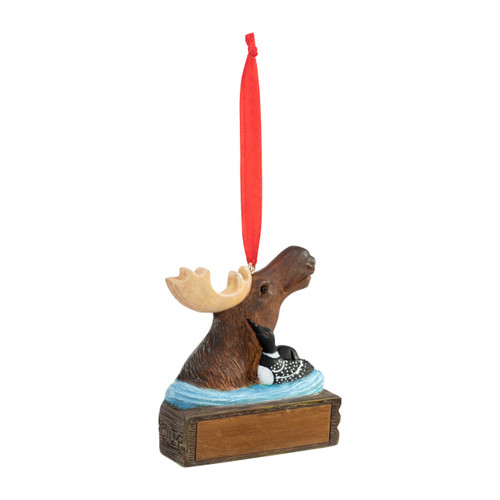 An ornament of a moose in the water next to a duck, hanging from a red ribbon. There is a spot in front for customization, displayed angled to the right.