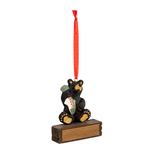 A hanging ornament with a black bear sitting and holding a fish on a rectangular base that can be personalized, displayed angled to the right.