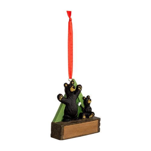 A hanging ornament with two black bears in front of a green tent on a rectangular base that can be personalized, displayed angled to the right.