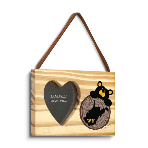 A rectangular wood hanging ornament with a 2x2 inch heart shaped photo opening next to an image of a black bear peeking over a wood stump with West Virginia on it, displayed angled to the right.