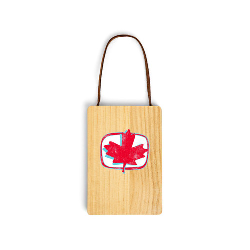 A wood hanging gift card ornament with an illustration of a red maple leaf on a white background on the front. The back has a holder for a gift card.