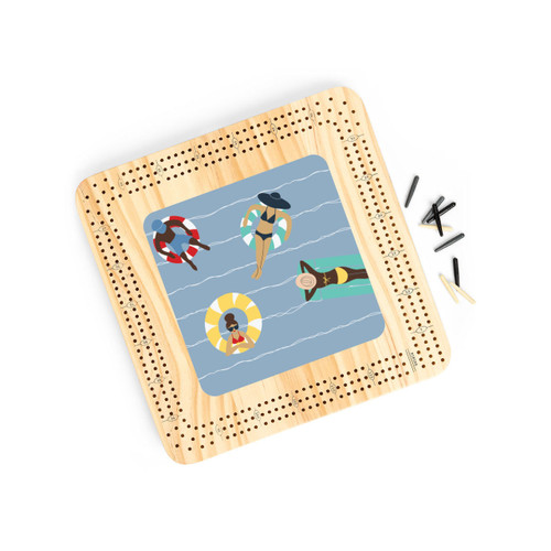 A light wood cribbage board with an illustration of people on floats in the water, displayed angled to the right with the playing pieces to the side.