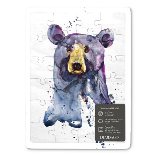 A 24 piece puzzle postcard with the watercolor image of a black bear's face, displayed with a product sticker attached.