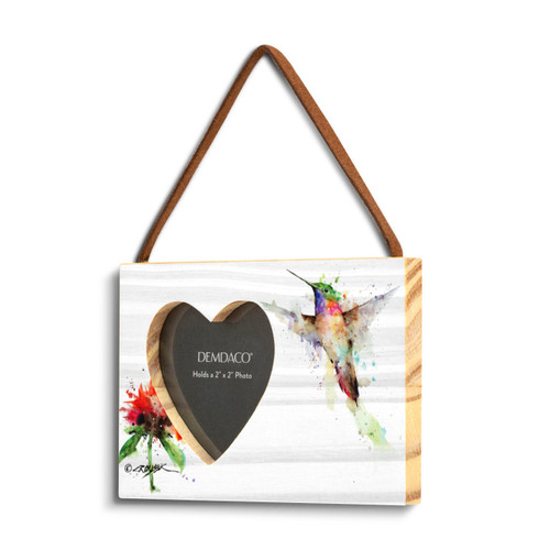 A rectangular wood hanging frame with a heart shaped 2 inch photo opening next to a watercolor image of a hummingbird and red flower, displayed angled to the left.