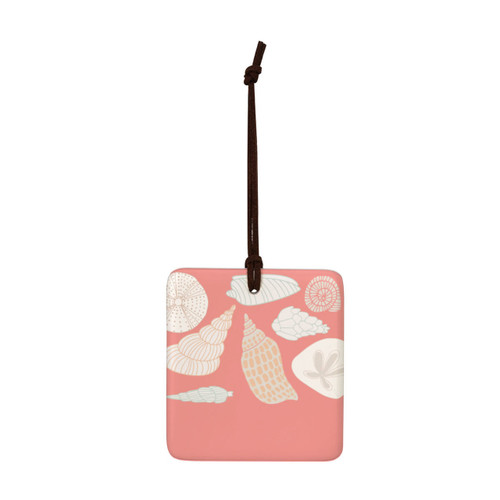 A square peach colored hanging tile magnet ornament with an illustration of different seashells.