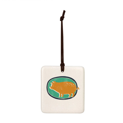 A square white tile hanging magnet ornament with a gold pig on a green background.