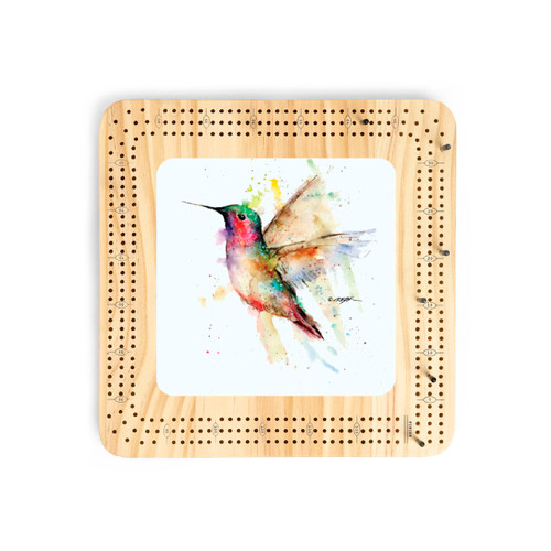 A light wood cribbage board with a watercolor image of a hummingbird in the flight in the middle.