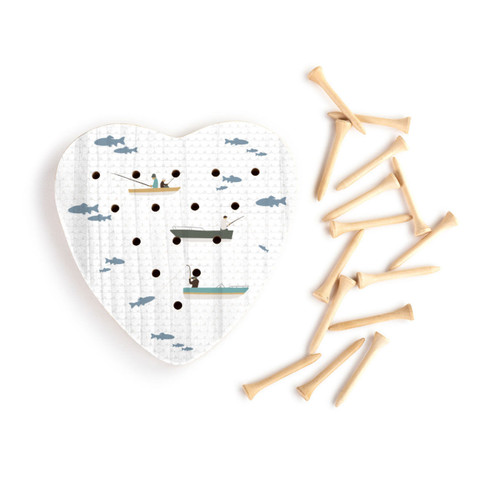 A white wood heart shaped peg game with an illustration of fishing boats and fish, displayed with the wood pegs out and to the side.