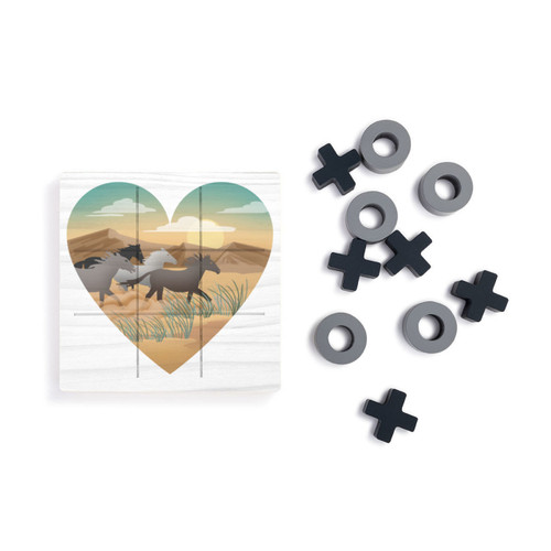 A square white wood board for tic tac toe with heart shaped graphic artwork of horses running in a southwest setting, displayed next to a set of X's and O's in gray and black.