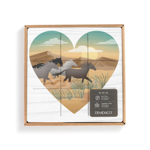 A square white wood board for tic tac toe with heart shaped graphic artwork of horses running in a southwest setting, displayed in a packaging box.