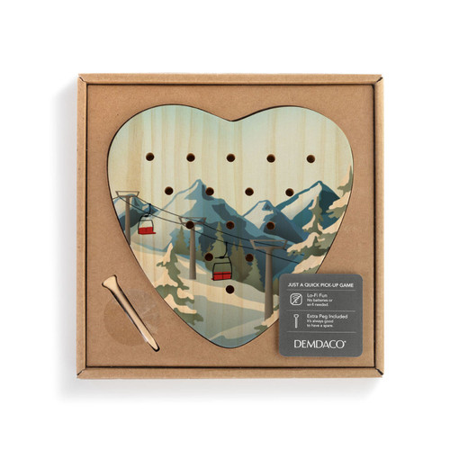 A wood heart shaped peg game with graphic artwork of a ski lift and snowy mountainside, displayed in a packaging box.