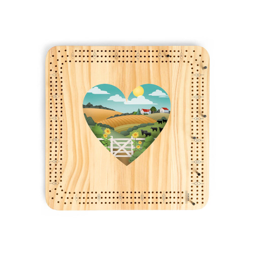 A light wood cribbage board game with heart shaped graphic artwork of a hilly farmstead and pasture in the middle.