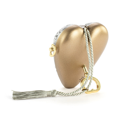 Back view showing the heart propped on the key for a silver heart shaped musical sculpture with a floral pattern that reads "Love You Mom". The heart has a silver tassel and gold key attached.