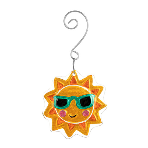 An orange sun glass ornament with sunglasses and a smile with a curved silver hanger.