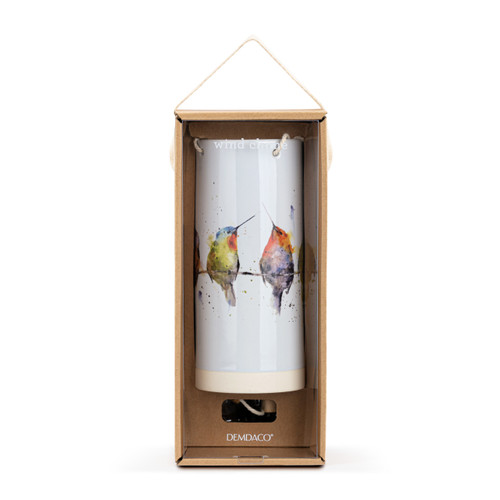 A white tubular ceramic wind chime with a wood chime. There are watercolor hummingbirds on a wire around the outside, displayed in a packaging box.
