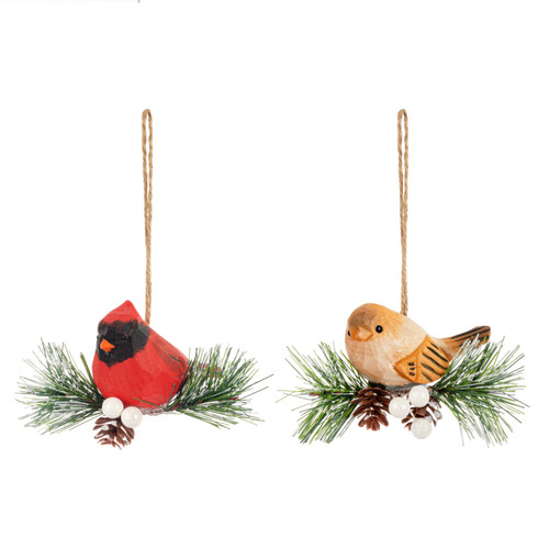 A pair of cardinal ornaments each sitting on a small evergreen branch, displayed angled to the left.