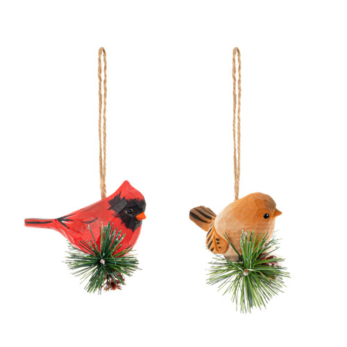 A pair of cardinal ornaments each sitting on a small evergreen branch, displayed angled to the right.