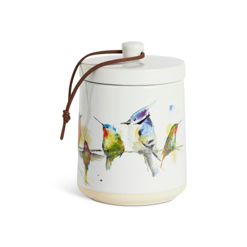 A white ceramic candle with watercolor songbirds on the outside and a removable lid.