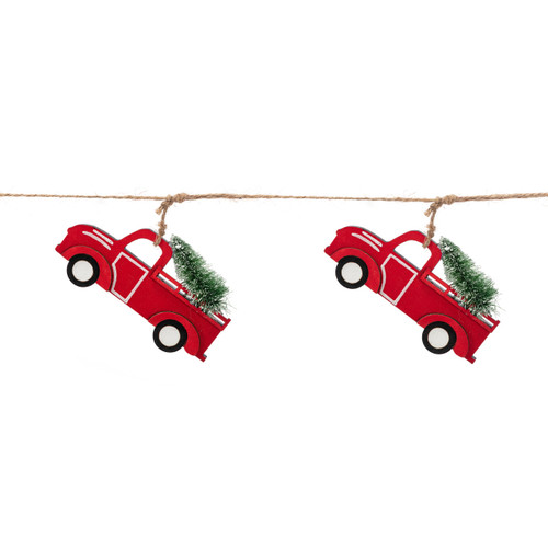 Detail view of two of the trucks on a garland made of little red wood truck cutouts. Each truck is carrying a Christmas tree.