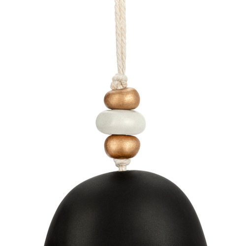 Detail view of the beads on a black decorative bell with the nativity scene in white and beads at the top.