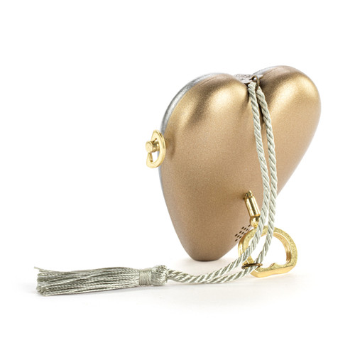 Back view showing the heart propped on the key for a silver heart shaped musical sculpture with a heart pattern that reads "You Fill My Heart With Love". The heart has a silver tassel and gold key attached.
