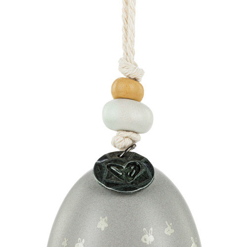 Detail view of the beads on a mini gray bell with the word "grateful". There are beads and a metal token at the top of the bell.