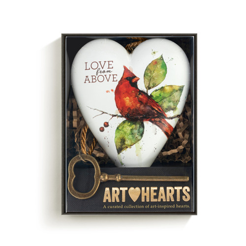 Heart shaped sculpture with a gold tassel and metal key attached. The heart is white with a red cardinal perched on a branch and says "Love from Above", displayed in a packaging box.