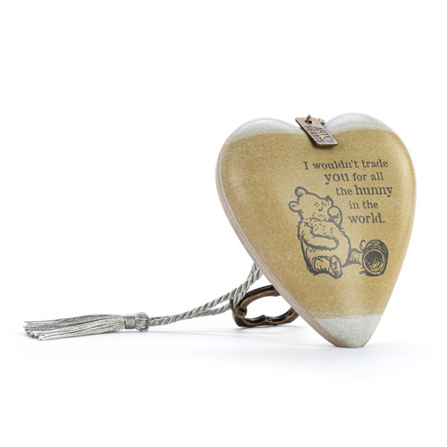 Heart shaped sculpture with a silver tassel and metal key attached. The heart has the image of Pooh eating honey on a brown background and says "I wouldn't trade you for all the hunny in the world", displayed angled to the right.