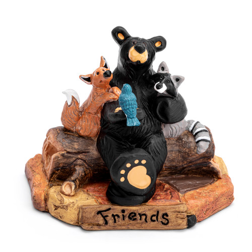 A figurine of a black bear sitting on a log with his forest friends including a fox, racoon and bird. The base says "Friends".