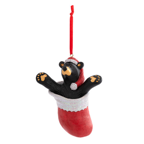 A hanging ornament of a black bear wearing a red Santa hat inside a red stocking, displayed angled to the left.