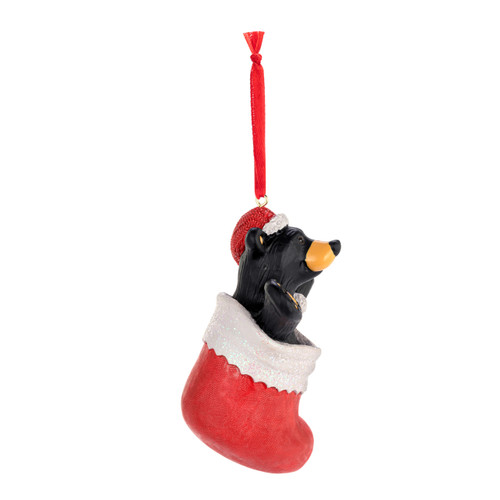 Right profile view of a hanging ornament of a black bear wearing a red Santa hat inside a red stocking.