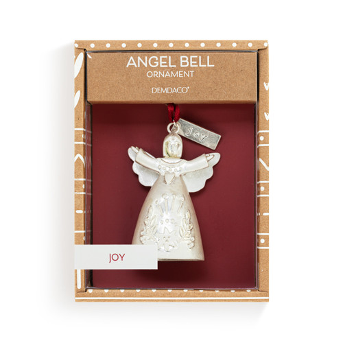 A mini white bell ornament shaped like an angel with her arms spread wide. There is a tag at the top with the word "Joy", displayed in a packaging box.