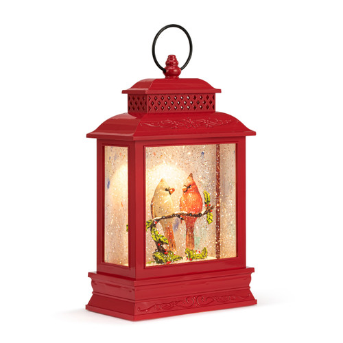A red lit musical lantern with the image of a cardinal pair sitting on a branch in the snow, displayed angled to the right.