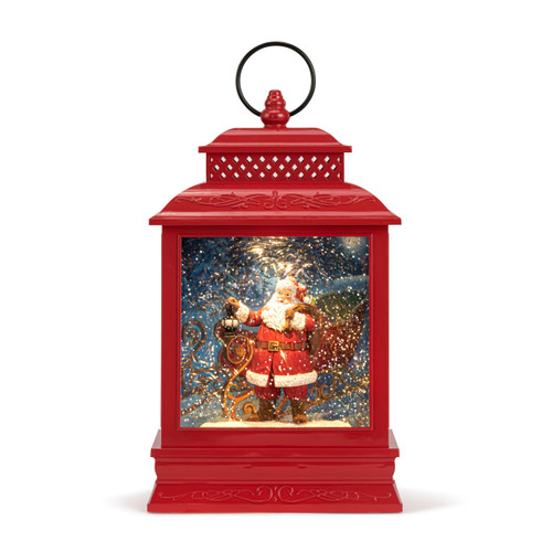 A red lit musical lantern with the image of Santa standing by his sleigh in the snow.