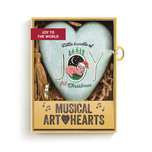 A light blue heart shaped musical sculpture with the saying "Little bundle of Joy 1st Christmas" with a little bear sleeping in the O of Joy. The heart has a gold tassel and gold key attached, displayed in a packaging box.