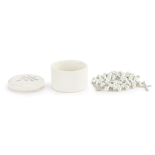 A round white ceramic trinket box next to a silver and white bead rosary, displayed with the box lid off and to the side.