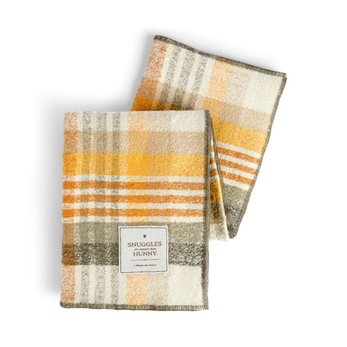 A yellow, cream and brown plaid blanket with a fabric tag that says "Snuggles are sweeter than Hunny" in the bottom right corner.