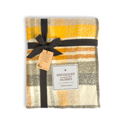 A yellow, cream and brown plaid blanket with a fabric tag that says "Snuggles are sweeter than Hunny" in the bottom right corner, displayed folded and tied in packaging.
