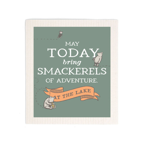 A green biodegradable dish cloth that says "May Today bring Smackerels of Adventure at the Lake" with small images of Pooh and Piglet.