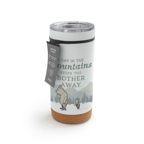 A white cork bottom tumbler with a clear plastic lid. The tumbler has an image of Pooh and Piglet in front of the mountains and says "A Day In The mountains Keeps The Bother Away.", displayed with a product tag attached.