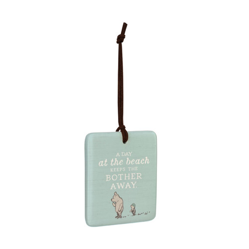 A square light blue hanging tile magnet ornament that says "A Day at the beach Keeps the Bother Away" with an image of Pooh and Piglet, displayed angled to the right.
