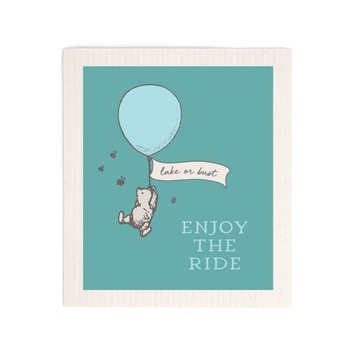 A green biodegradable dish cloth that says "Enjoy The Ride" with Pooh hanging from a balloon that says "lake or bust".