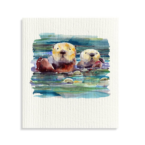 A white biodegradable dish cloth with a watercolor image of two otters in the water.