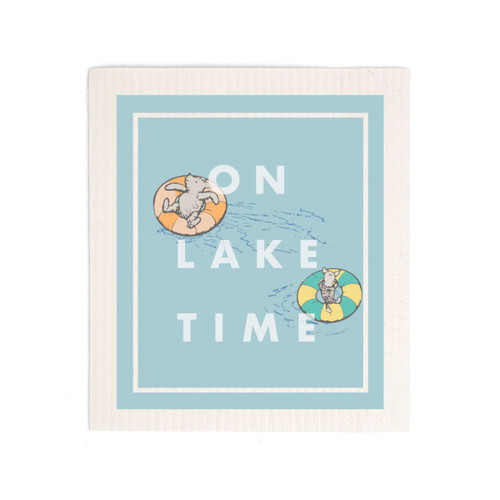 A light blue biodegradable dish cloth that says "On Lake Time" with an image of Pooh and Piglet on inflatable floats.