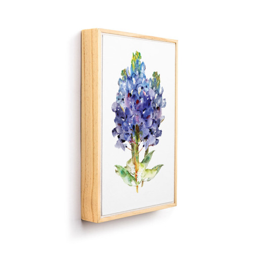 A light wood framed wall art of a watercolor bluebonnet, displayed angled to the right.