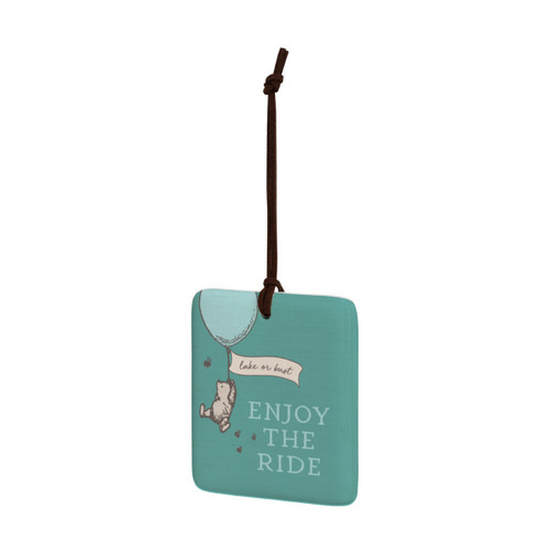 A square green hanging tile magnet ornament that says "Enjoy The Ride" with an image of Pooh hanging on a balloon that says "lake or bust", displayed angled to the left.