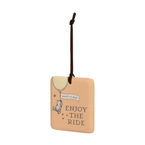 A square orange hanging tile magnet ornament that says "Enjoy The Ride", with an image of Pooh hanging from a balloon that says "beach or bust", displayed angled to the left.